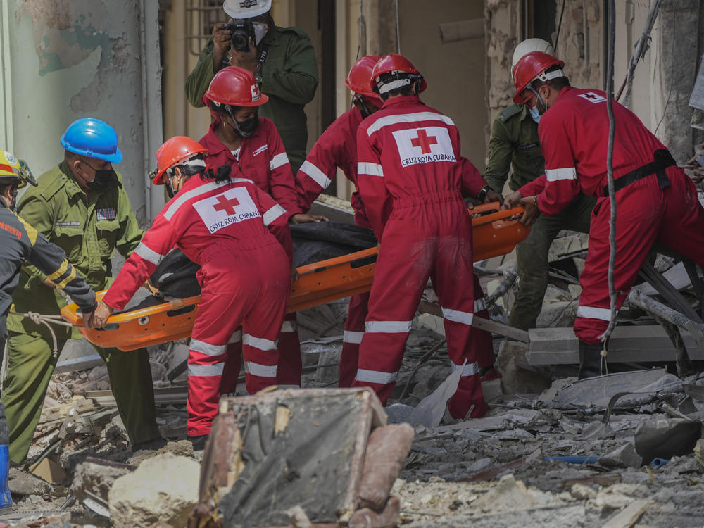 Rescuers recover a body at the site of Friday's deadly explosion that destroyed the five-star Hotel Saratoga, in Havana, Cuba, Saturday, May 7, 2022.