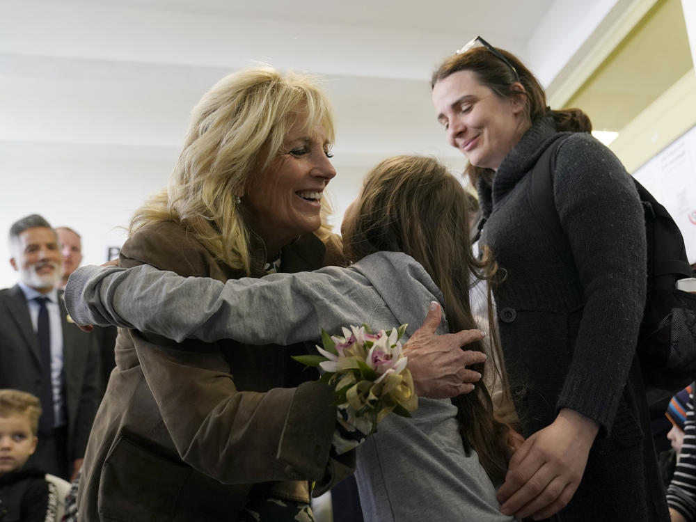 First lady Jill Biden gets a hug from Ukrainian refugee Yulie Kutocha, 7, as her mother Victorie Kutocha, watches at right, during a visit to a city-run refugee center in Kosice, Slovakia, Sunday, May 8, 2022.
