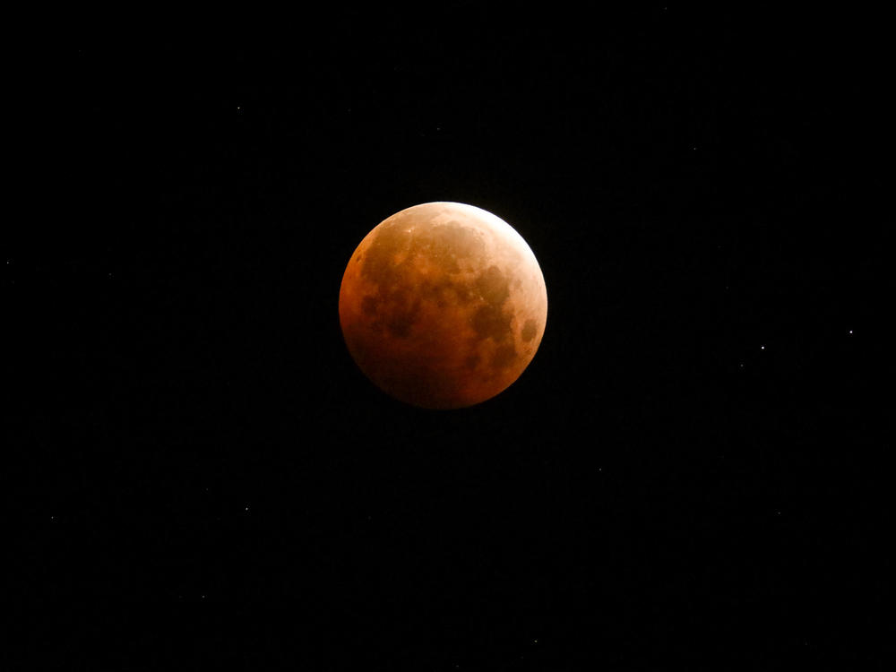 Light shines from a total lunar eclipse over Santa Monica Beach, Calif., in May 2021.