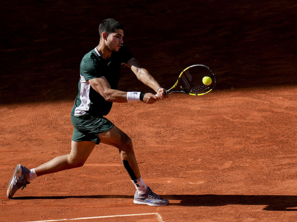 Carlos Alcaraz hits a return to Novak Djokovic on his way to a semifinal win at the Madrid Open tennis tournament. Alcaraz went on to win the tournament, moving him higher in the world's top 10.