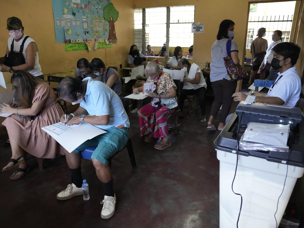 People vote at a school used as a polling center Monday, in Quezon City, Philippines.