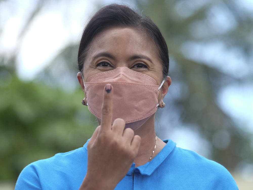 Presidential candidate and incumbent Vice President Leni Robredo shows the ink on her finger to mark that she has finished voting at a school used as a polling center in Camarines Sur, Philippines on Monday.