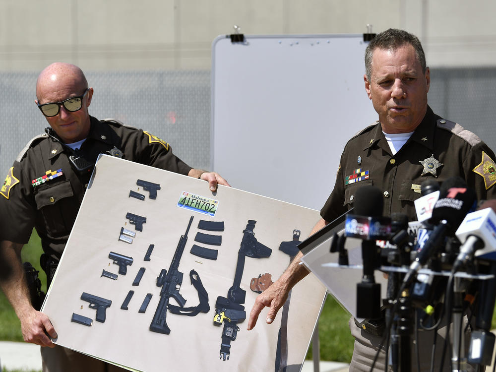 During a news conference in Evansville, Ind., on Tuesday, Vanderburgh County Sheriff Dave Wedding shows a photograph of the weapons that were found in the possession of fugitives Casey White and Vicky White following their capture.