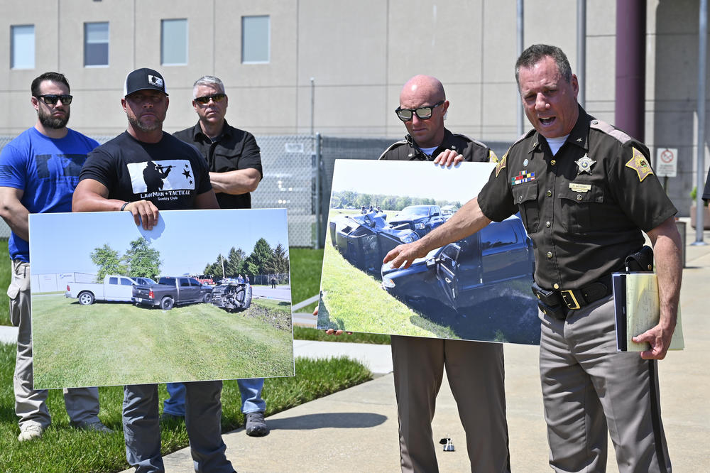 Vandenburgh County Sheriff Dave Wedding (right) refers to a photograph during a news conference on Tuesday.