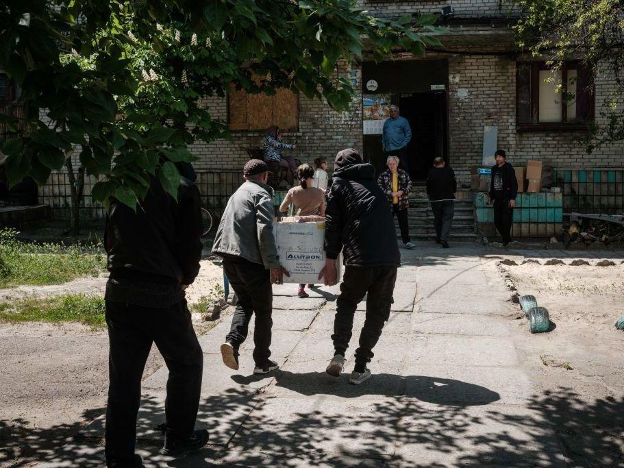 Residents receive food supplies May 7 as volunteers deliver daily from a warehouse of a humanitarian aid distribution center in Severodonetsk, eastern Ukraine