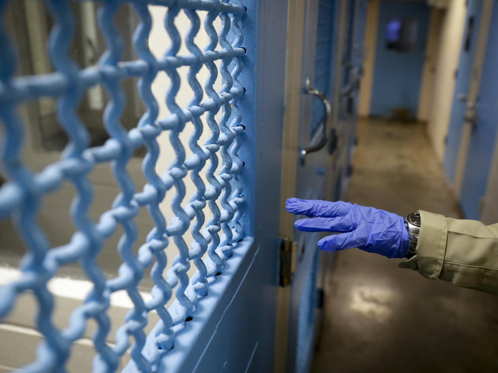 A gloved hand points to a holding cell at the hospital ward of the Twin Towers jail in Los Angeles in April 2020.
