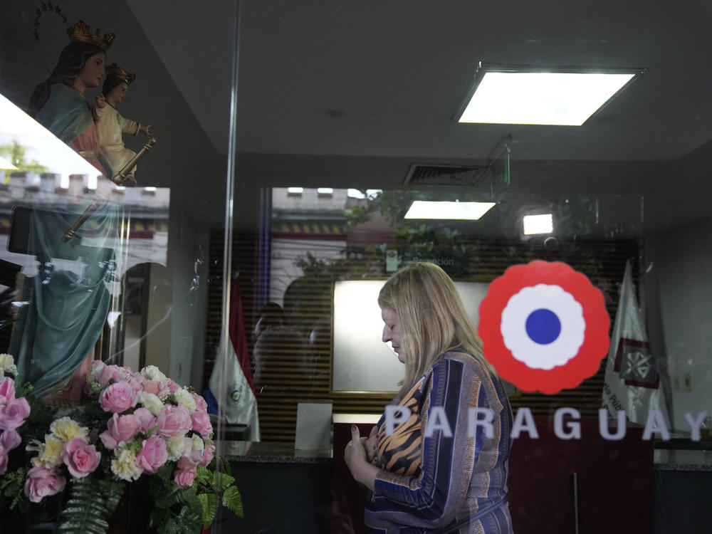 Paraguay Attorney General Sandra Quiñonez prays to a Virgin Mary statue at the entrance of her office in Asuncion, Paraguay, after she found out about the killing of Paraguayan prosecutor Marcelo Pecci on Tuesday.