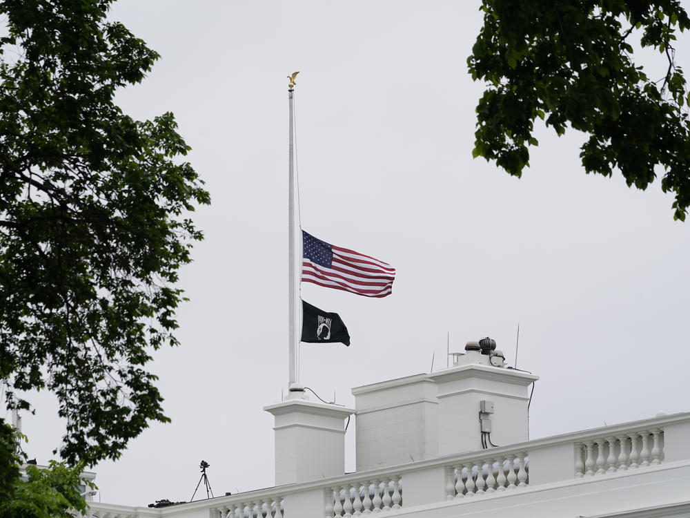 The American flag flies at half-staff at the White House on Thursday as President Biden commemorates 1 million American lives lost due to COVID-19.