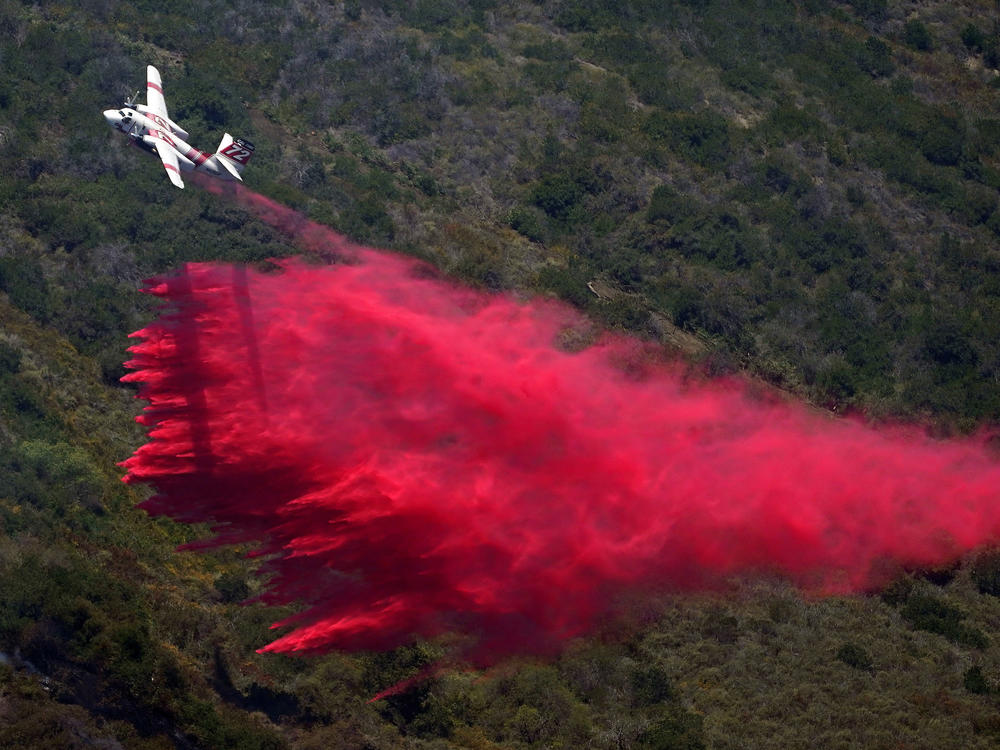 A plane drops fire retardant onto the fire on Thursday in Laguna Niguel, Calif.