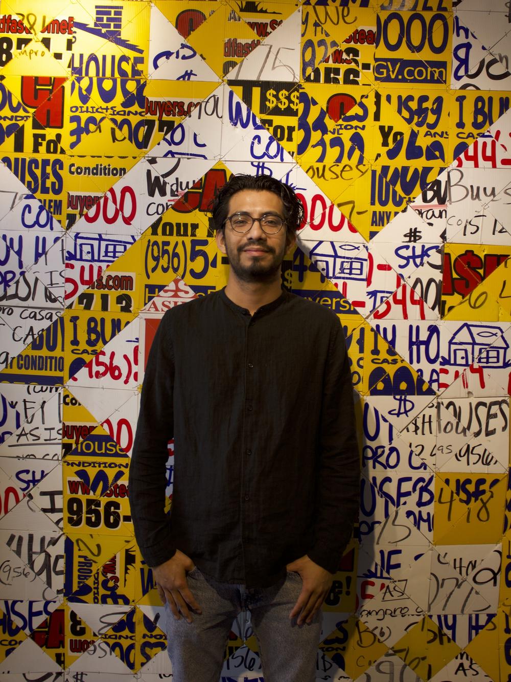 Artist and writer Josué Ramirez stands before one of his pieces at his gallery 