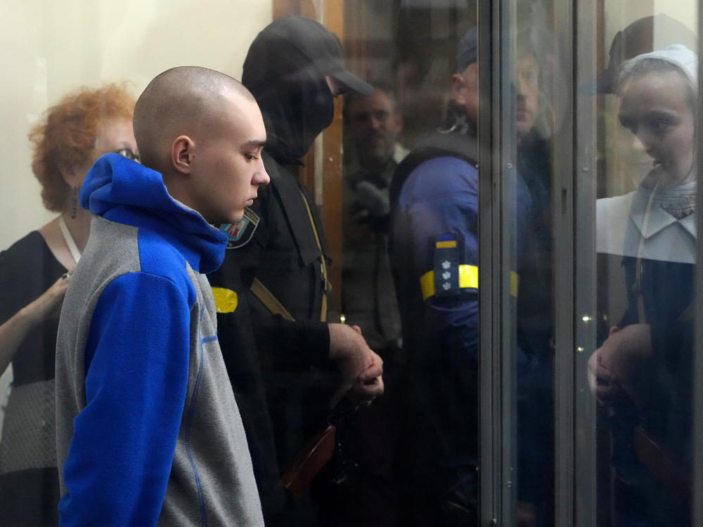 Russian army Sgt. Vadim Shishimarin, 21, is seen behind a glass during a court hearing in Kyiv, Ukraine, on Friday. He is accused of killing a Ukrainian civilian. The first war crimes trial since Moscow's invasion of its neighbor opened Friday.