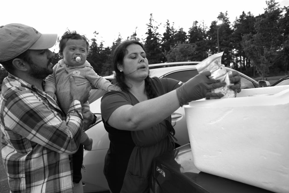 Cris Matocchi (left) holds Tabitha Sierra's youngest child on May 28, 2020. Matocchi and Sierra have been tasked with testing more than 3,000 people on the island.