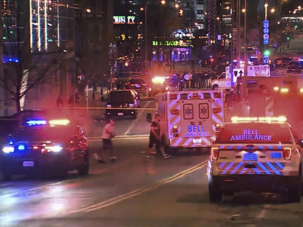 This photo taken from video provided by WISN 12 News shows police responding to the scene of a shooting at Water Street and Juneau Avenue in Milwaukee Friday night. At least 20 people were injured in two shootings.