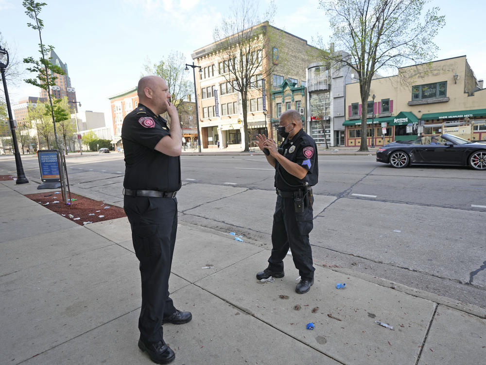Milwaukee School of Engineering public safety officers investigate the scene of a shooting near the corner of North Water Street and East Juneau Avenue in Milwaukee on Saturday.