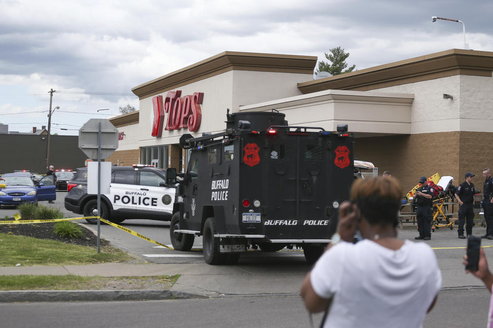 A crowd gathers as police investigate a shooting at a supermarket on Saturday in Buffalo, N.Y.
