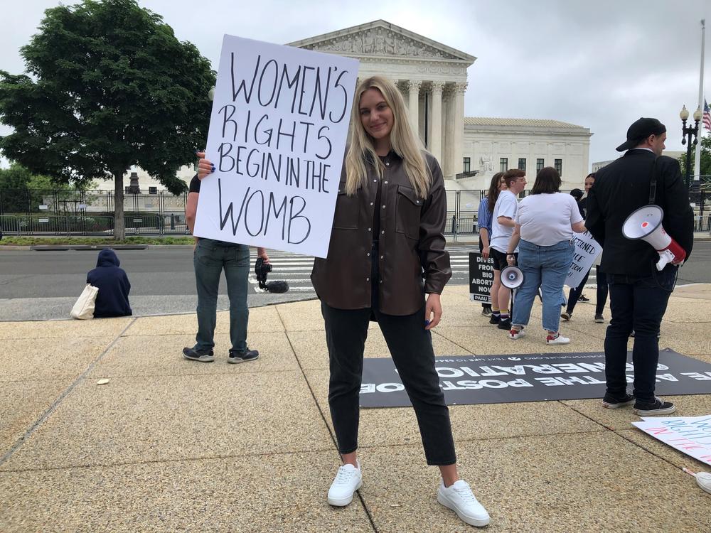 Anna Lulis holds a sign that reads 