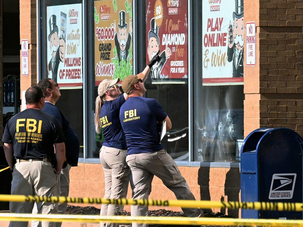 FBI agents look at the bullet impacts at the Tops grocery store in Buffalo, on Sunday.