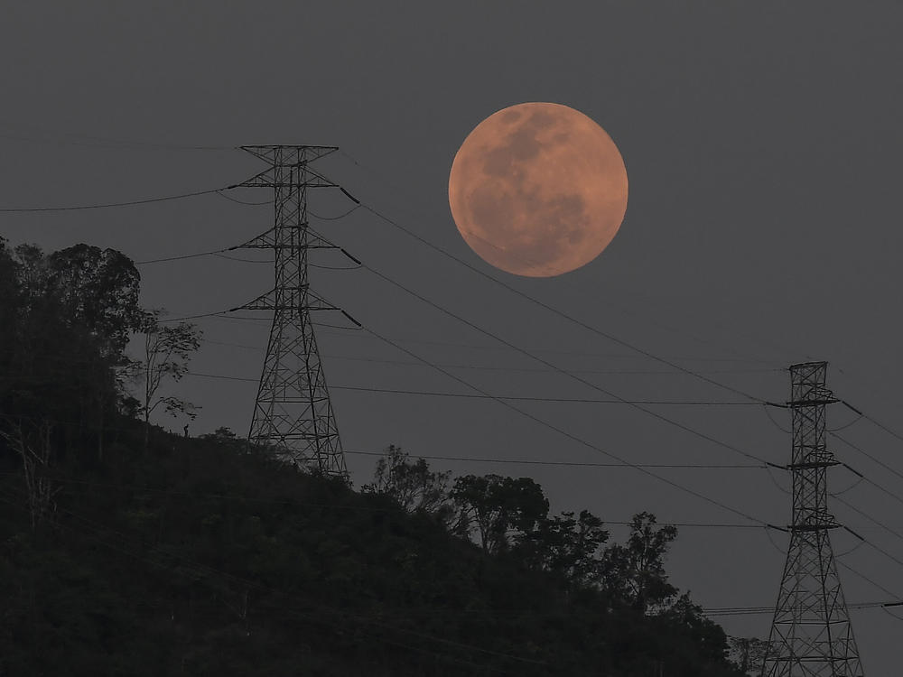 A full moon rises behind the high voltage towers of the El Avila in Caracas, Venezuela, Sunday, May 15. People in the Americas, Europe and Africa had a chance to see the total lunar eclipse that began Sunday night.