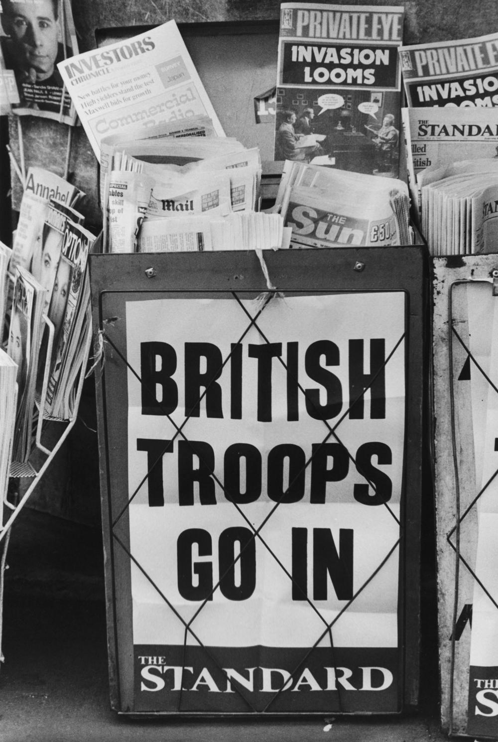 An<em> Evening Standard</em> headline on a London newspaper stand in May 1982 reads, 'British Troops Go In'.