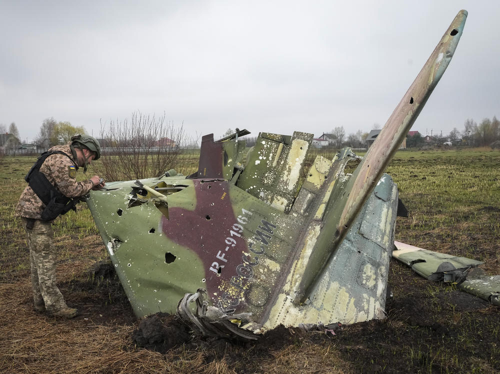 A Ukrainian soldier examines a fragment of a Russian Air Force Su-25 jet after a battle at the village of Kolonshchyna, Ukraine, on April 21. Russia was expected to establish air superiority in the first days of the war. But Ukraine's air defenses have been so effective that Russian pilots often fire their weapons while over Russia and never enter Ukrainian airspace.
