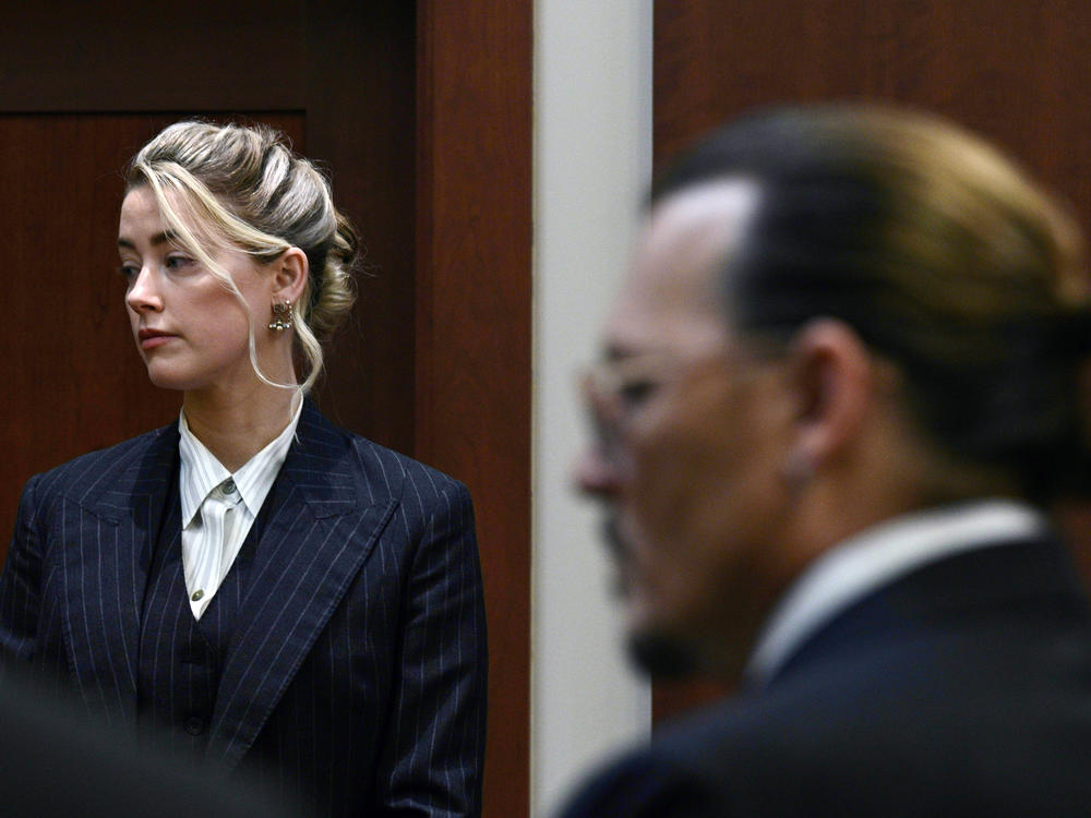 Actors Amber Heard and Johnny Depp watch the jury arrive in the courtroom at the Fairfax County Circuit Court in Fairfax, Va. on Tuesday.