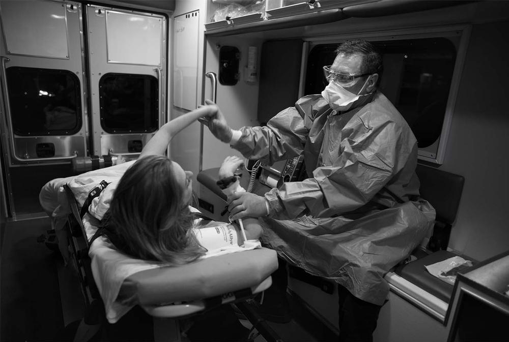 Doug Neal tries to calm a patient in an ambulance in May of 2020.