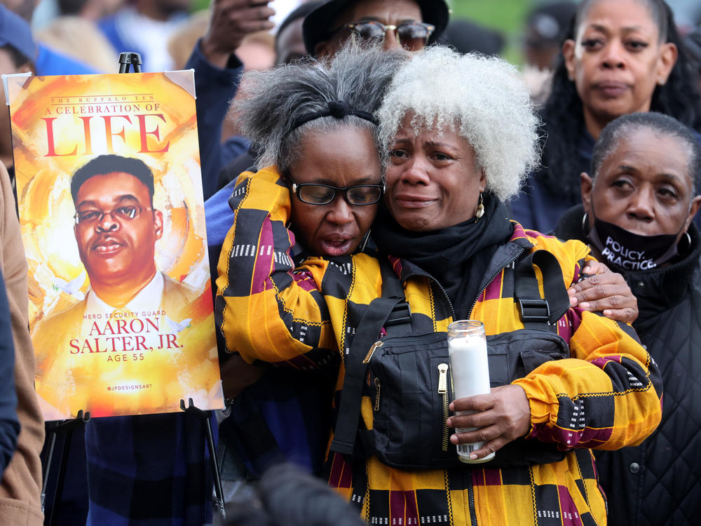 People participate in a vigil to honor the 10 people killed in Saturday's shooting at Tops market in Buffalo, New York.