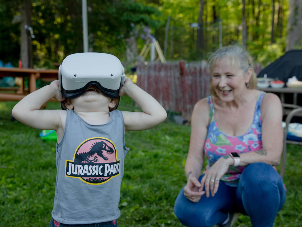 Linda Munson's youngest grandson, Daniel Gomez, 2, tries on an Oculus headset in her yard in Berlin, Conn. Playing different virtual reality games has become her family's regular Sunday activity, Munson said.