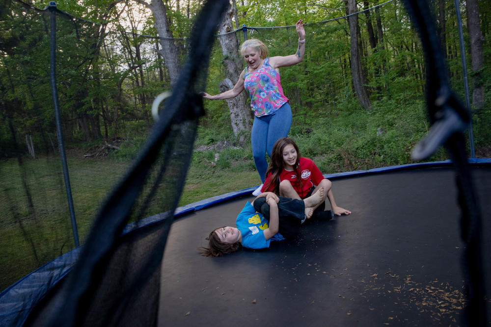 Linda Munson, 56, jumps on a trampoline in her yard with her grandchildren, Christopher Gomez, 8, (left) and Andrew Gomez, 11. 