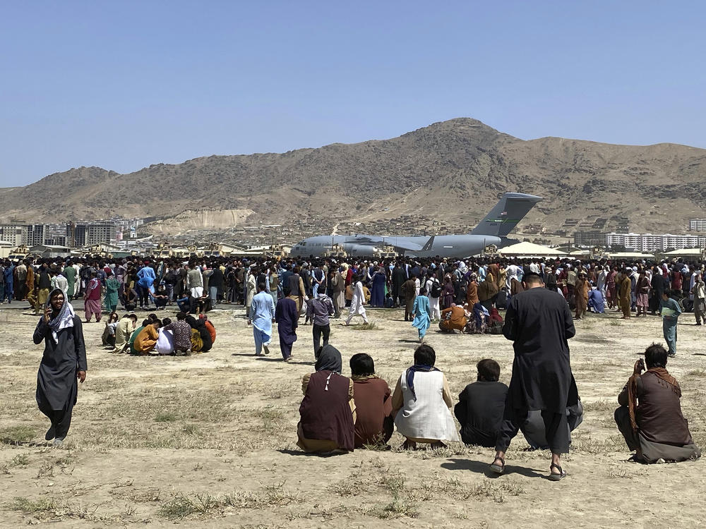 Hundreds of people gather near a U.S. Air Force C-17 transport plane at the perimeter of the international airport in Kabul, Afghanistan, on Aug. 16, 2021. SIGAR, released its interim report Wednesday detailing why Afghanistan's government and military collapsed immediately after the U.S. withdrawal.