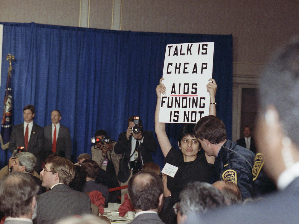 Urvashi Vaid, then-executive director of the National Gay and Lesbian Task Force, protests at then-President George H.W. Bush's address on AIDS in March 1990 in Arlington, Virginia. The pioneering LGBTQ activist and attorney died last week at age 63.