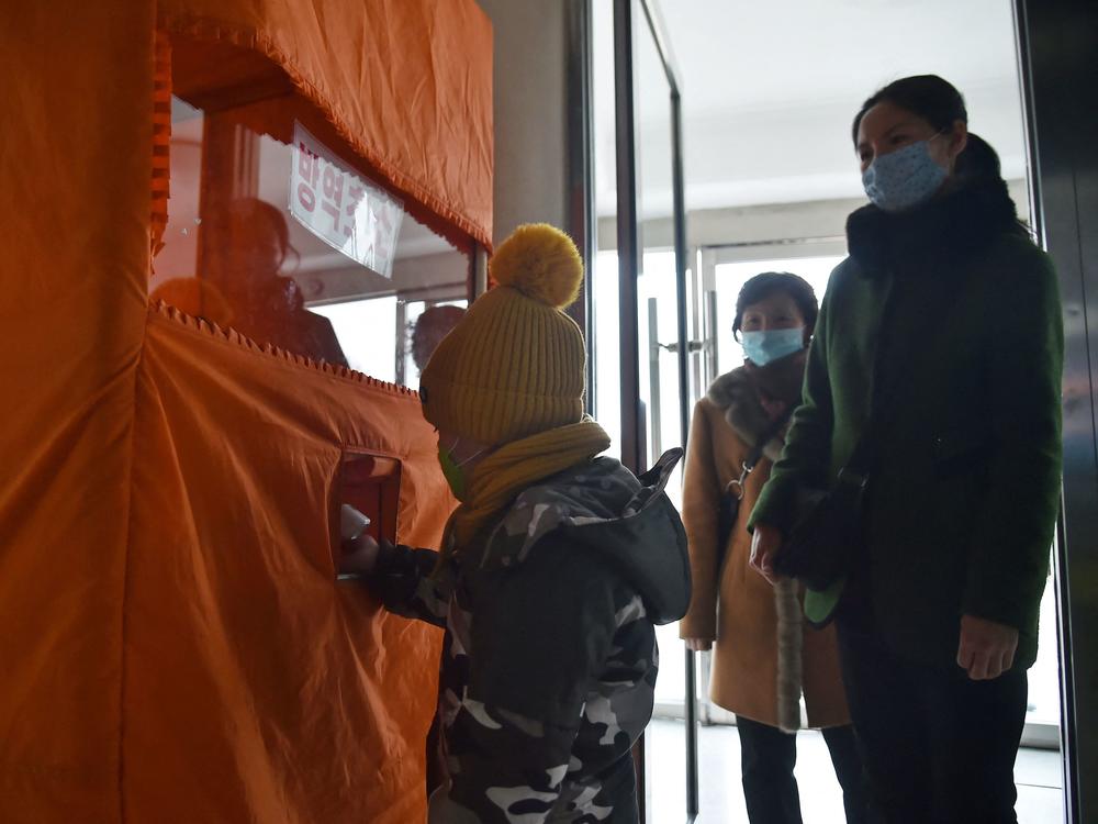 A child's temperature is checked and hands sanitized before entering the Pyongyang Children's Department Store as part of preventative measures against COVID.