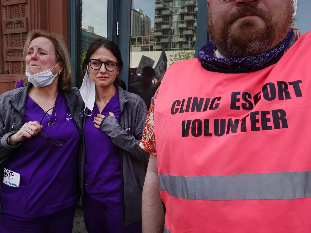 Workers at a family planning health center get emotional as thousands of abortion rights advocates march past their clinic on their way into downtown Chicago on May 14, 2022.