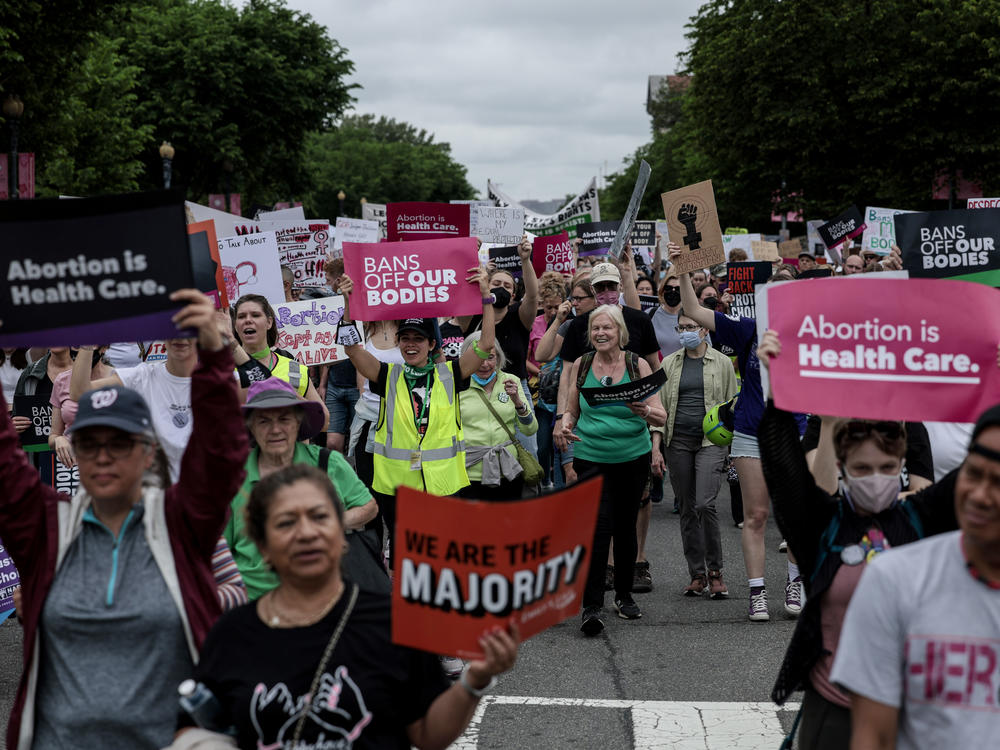 Pro-abortion rights demonstrators march in Washington, D.C., on May 14. While most U.S. adults favor some restrictions on abortion, according to our new poll, most also say they do not support overturning <em>Roe v. Wade</em>.