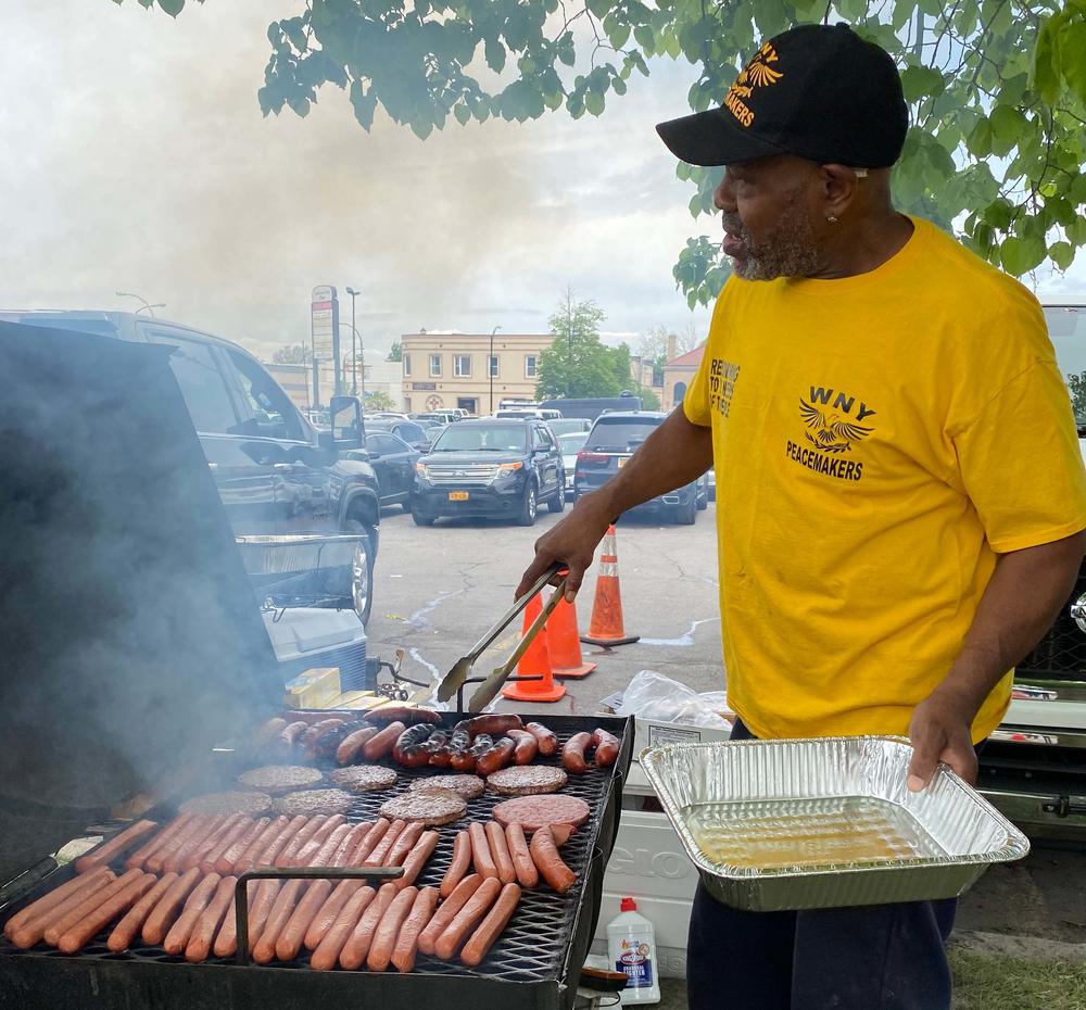 Michael King with the Buffalo Peacemakers mans the grill outside of the Tops supermarket.