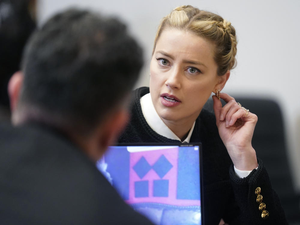 Actor Amber Heard speaks with a member of her legal team in the courtroom at the Fairfax County Circuit Court in Fairfax, Va. on Thursday.