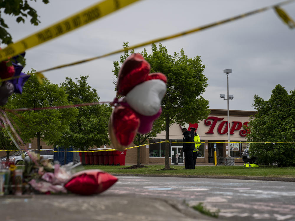 People gather at the scene of a mass shooting at Tops Friendly Market at Jefferson Avenue and Riley Street on Monday, May 16, 2022 in Buffalo, NY.