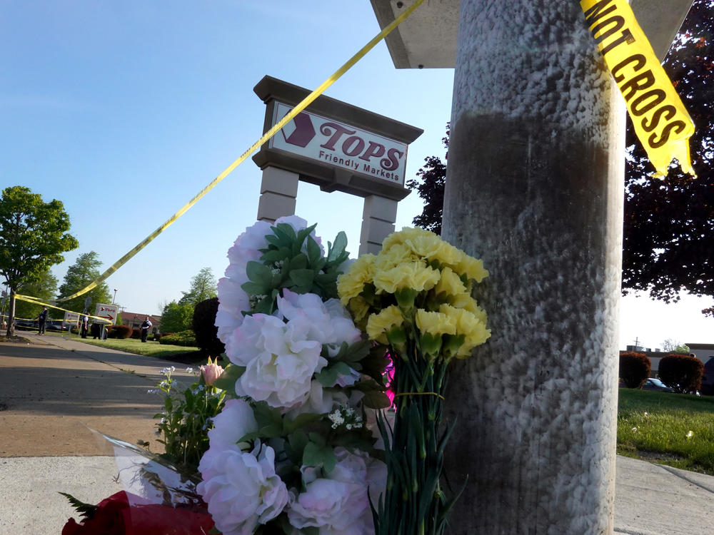 Flowers are left at a makeshift memorial outside of the Tops market on May 15 in Buffalo, N.Y.