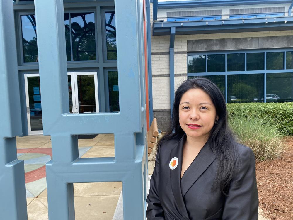Brenda Lopez Romero, Democratic Party chair in Gwinnett County, stands in front of an early voting center outside Norcross, Ga.