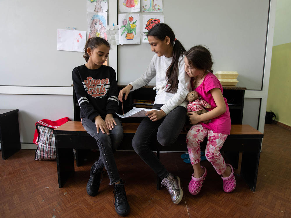 Raise Grigorievna Dreama's daughters Malina (left) and Ramina (center) and her granddaughter Monica (right) sit in their room at a temporary Chisinau housing center for refugees, mostly hosting people from the Roma community and other minority groups from Ukraine, in April.