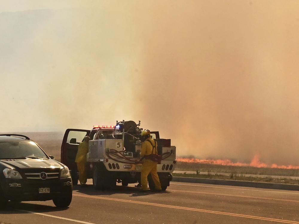 A firefighting crew arrives at the scene of a field on fire adjacent to an Amazon distribution center in Colorado Springs, Colo. on May 12, 2022.