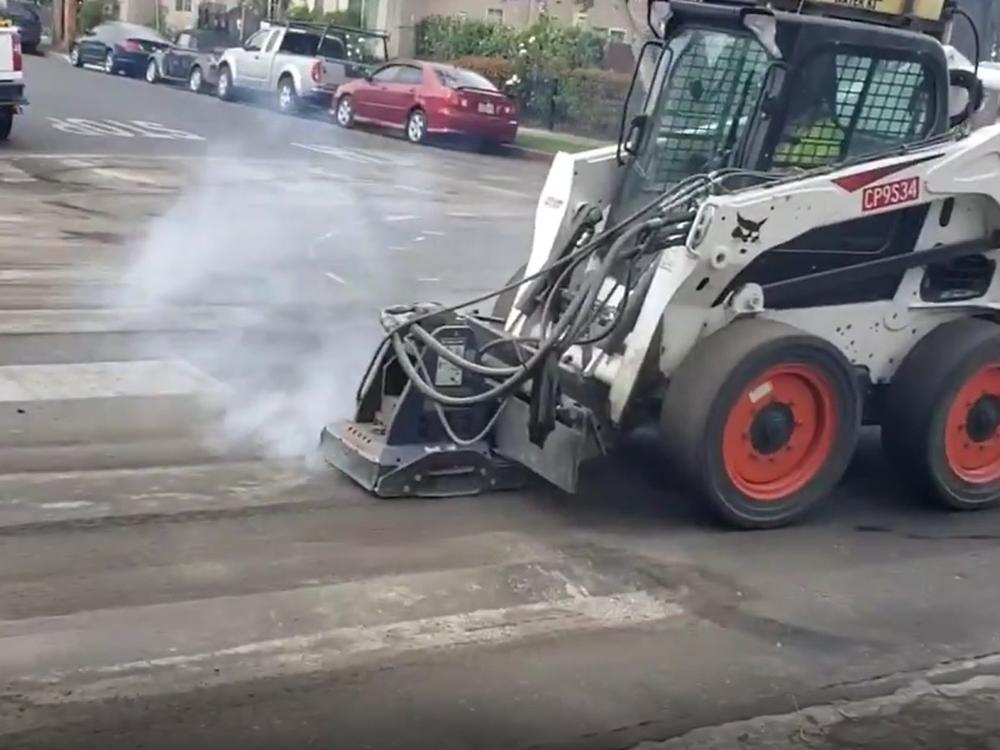 Los Angeles city workers working to remove the unauthorized crosswalks painted at the intersection of Romaine Street and N. Serrano Avenue.