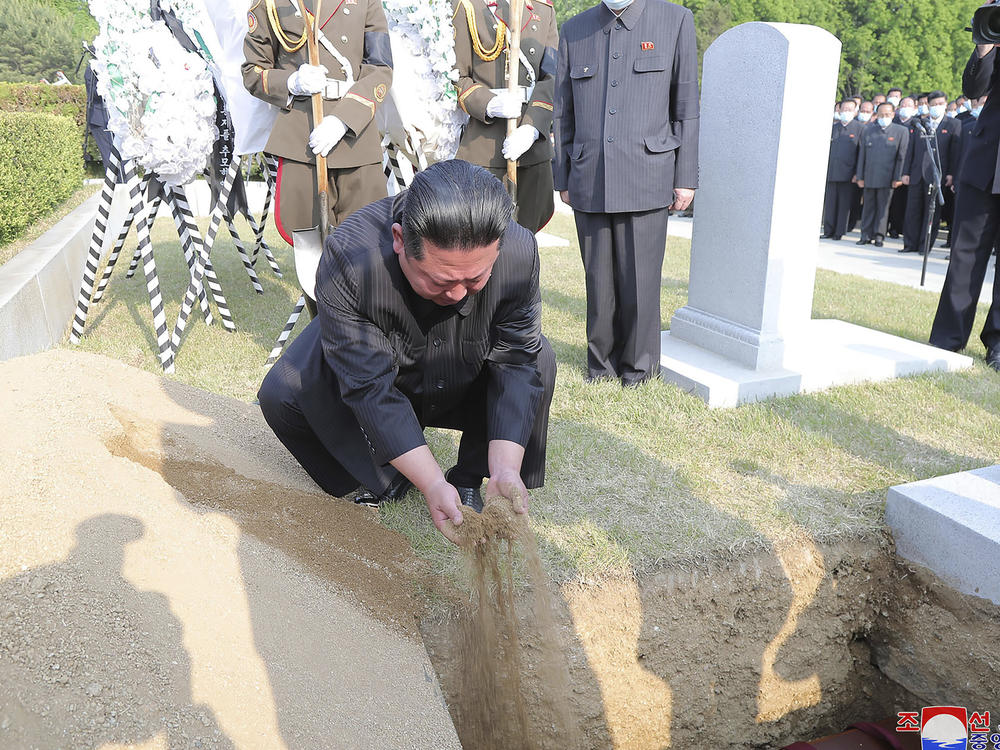 In this photo provided by the North Korean government, North Korean leader Kim Jong Un covers the coffin of Hyon Chol Hae, marshal of the Korean People's Army, with earth at a cemetery in Pyongyang, North Korea Sunday, May 22, 2022. The content of this image cannot be independently verified.