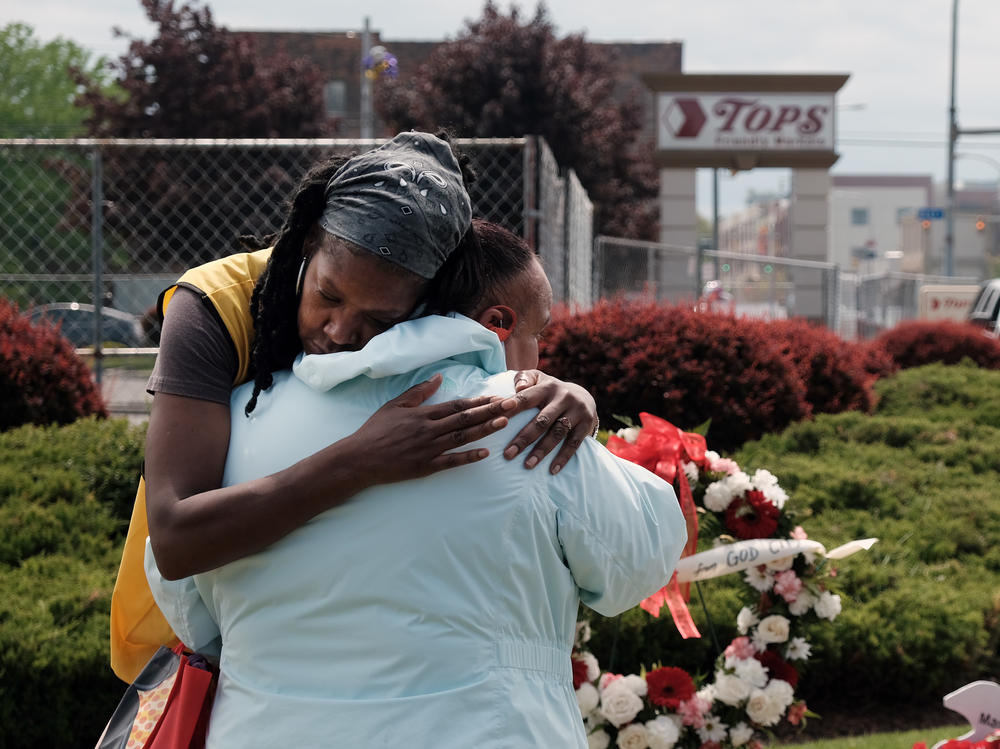 People embrace near a memorial for the shooting victims outside of Tops grocery store on May 20, 2022 in Buffalo, New York.