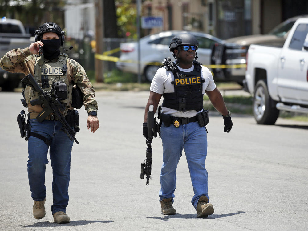 Police walk near Robb Elementary School in Uvalde, Texas, following Tuesday's mass shooting there.