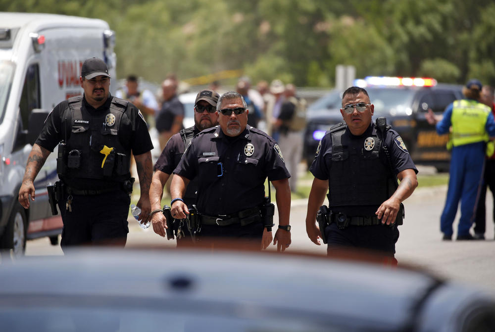 Police walk near Robb Elementary School following the shooting.