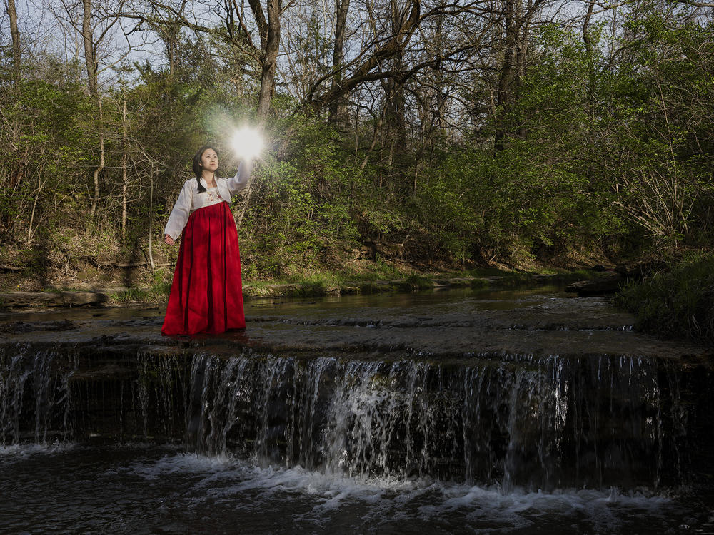 Arin Yoon recreates the scene from her mother's conception dream, holding jewels up to the light to discover the name of the child growing in her belly.