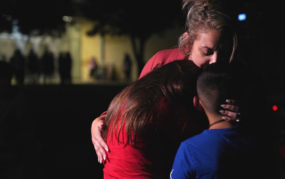 Families hug outside the Willie de Leon Civic Center where grief counseling will be offered.