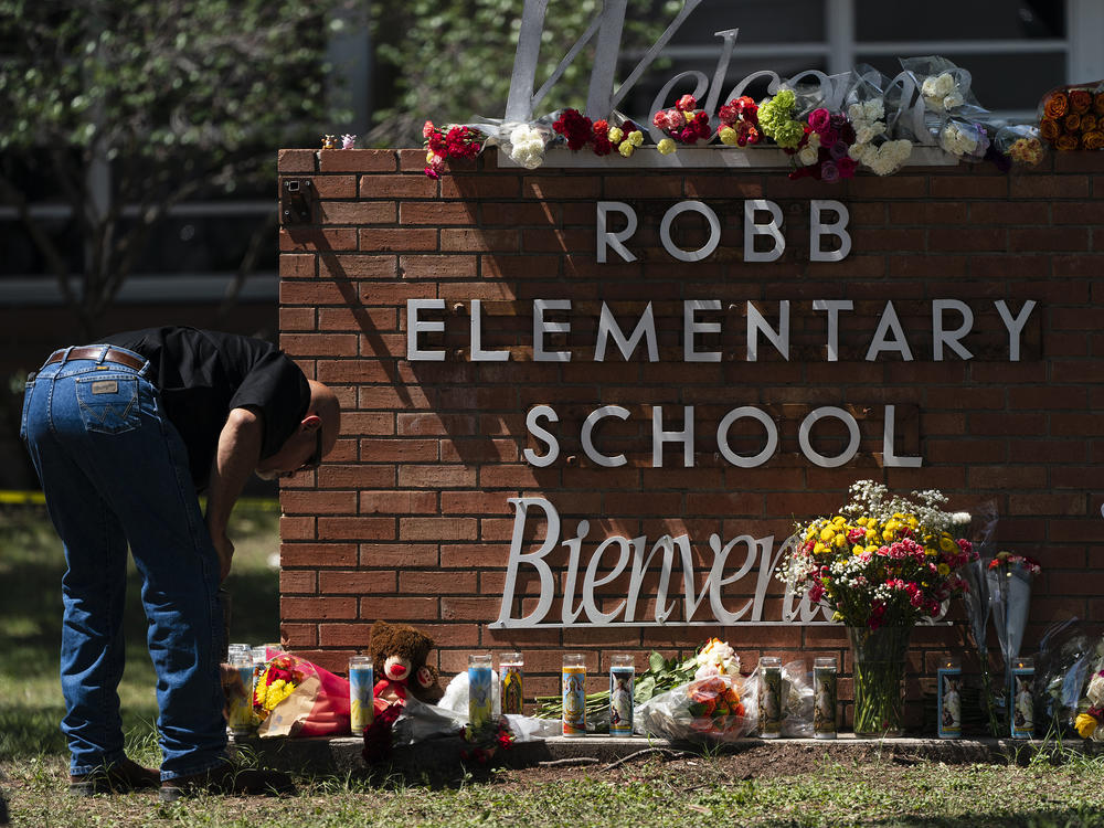 A law enforcement personnel lights a candle outside Robb Elementary School in Uvalde, Texas, Wednesday, May 25, 2022. Desperation turned to heart-wrenching sorrow for families of grade schoolers killed after an 18-year-old gunman barricaded himself in their Texas classroom and began shooting, killing several fourth-graders and their teachers.