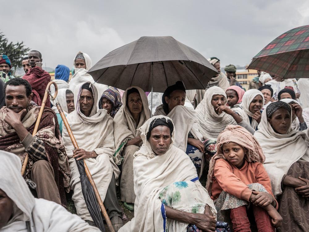 People who fled from fighting in Ethiopia gather in a temporary internally displaced people camp to receive first bags of wheat from the World Food Programme. Ethiopia saw a record 5.1 million displacements in 2021.